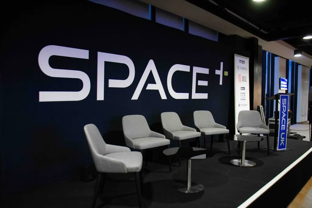 SPACE+ branded stage with lounge chairs at SPACE UK